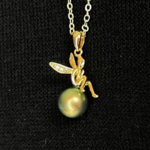 Golden fairy sitting on an iridescent green crystal pearl